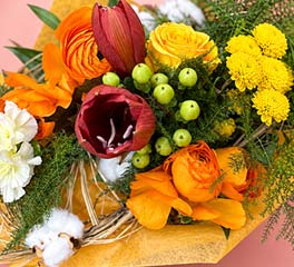 Bouquet aux tons orange et jaune composé de fleurs de saison et baies décoratives, création florale artisanale Rosae à Hyères