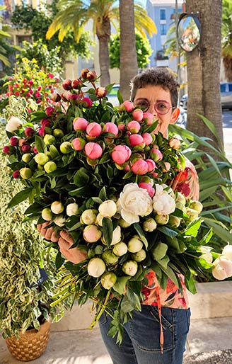 Sabrina, artisan fleuriste Rosae à Hyères, présentant un généreux bouquet de pivoines roses et blanches