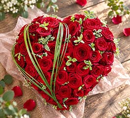 Composition florale en forme de cœur réalisée avec des roses rouges et du feuillage, création artisanale Rosae à Hyères