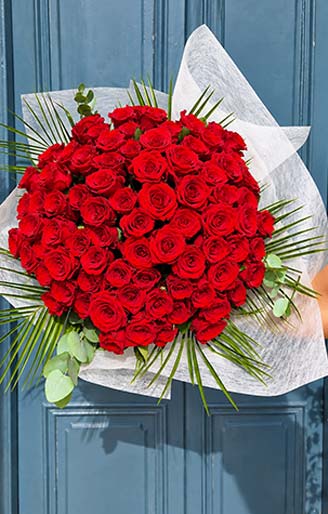 Grand bouquet rond de roses rouges et feuillage réalisé par Rosae, artisan fleuriste à Hyères