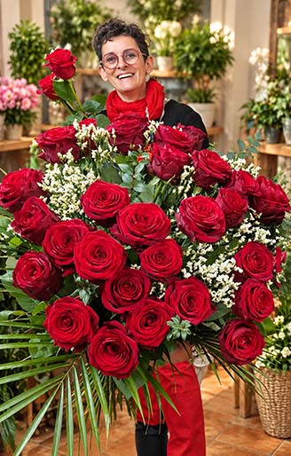 Sabrina, artisan fleuriste Rosae à Hyères, présentant un généreux bouquet de roses rouges et de feuillage