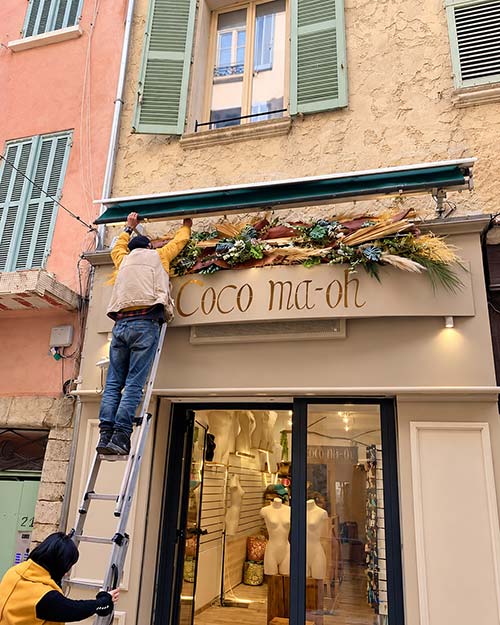 Installation d’une décoration florale sur la vitrine d’un commerce à Hyères, réalisée sur mesure par Rosae