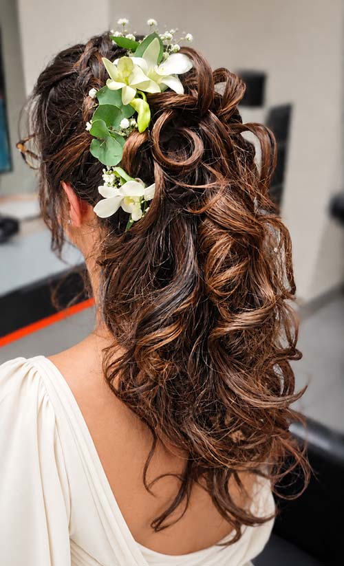 Fleurs blanches et feuillages intégrés dans une coiffure de mariée, création florale réalisée par Rosae à Hyères